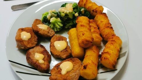 Auf einem Teller liegt gebratenes Schweinefilet mit Sauce Hollandaise, umgeben von Kroketten und Brokkoli.