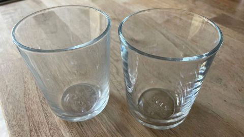 Zwei matte Gläser stehen auf einem Holzuntergrund, bereit, im Geschirrspüler glänzend gereinigt zu werden.