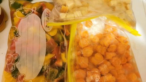 Gefrorenes Gemüse und Brot in beschrifteten Tüten sind ordentlich verstaut, um bei Lebensmitteln zu sparen und frisch zu bleiben.