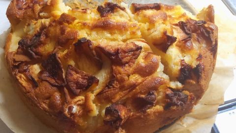 Saftiger Apfelkuchen aus der Heißluftfritteuse, goldbraun gebacken mit einer knusprigen Oberfläche, auf Backpapier serviert.