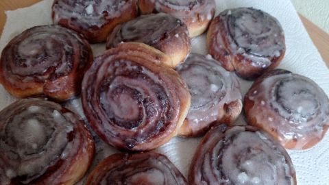 Auf einem Teller liegen frisch gebackene Nuss-Schnecken, glänzend und süß, auf Küchenpapier aus Ruhe.