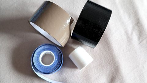 Klebeband liegt auf einem hellen Hintergrund, verschiedene Farben und Breiten deuten auf Anwendung gegen Warzen hin.