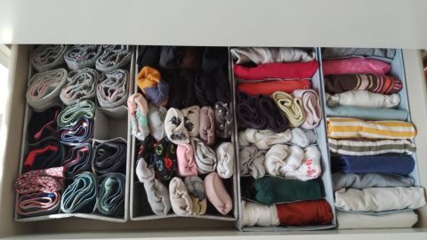 Gestapelte Socken und Unterwäsche sind ordentlich in einem Schubladen-Organizer angeordnet und sparen Platz.