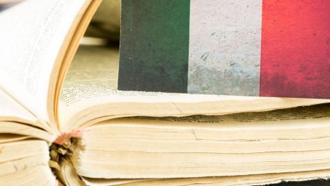 Ein aufgeschlagenes Buch liegt offen, während eine italienische Flagge darauf sichtbar ist. Typische italienische Begriffe werden vermittelt.