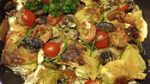 Maultaschen und Champignons werden in einer Pfanne gebraten, garniert mit Cherry-Tomaten und frischen Kräutern. Datum: 14. Aug. 2024, 13:56.