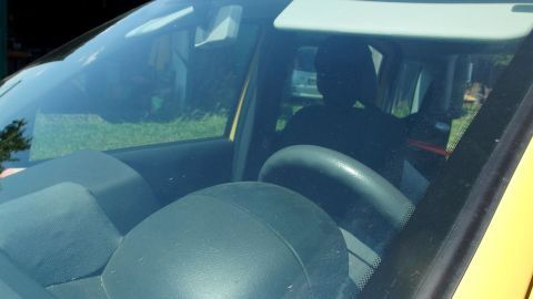 Eine saubere Autoscheibe reflektiert auf einem Parkplatz Licht; Autoscheibenwaschanlage optimiert Sichtklarheit im Freien.