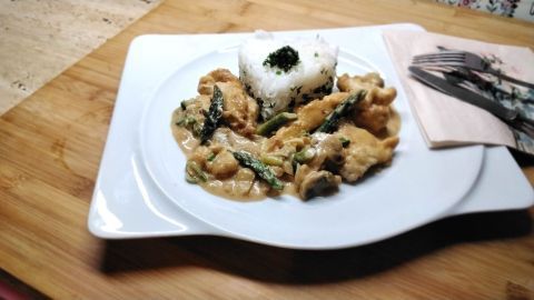 Putengeschnetzeltes mit Reis auf einem Teller: Eine köstliche Kombination aus zarten Champignons und Spargel in cremiger Sauce.