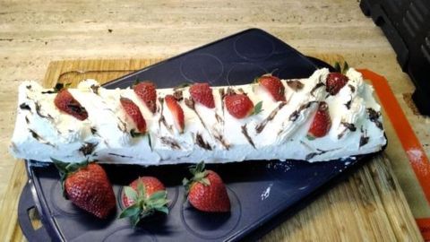 Genieße eine fruchtige Frischkäse-Biskuitrolle: Fluffiger Teig, frische Erdbeeren und Schokoraspel sorgen für ein perfektes Dessert.
