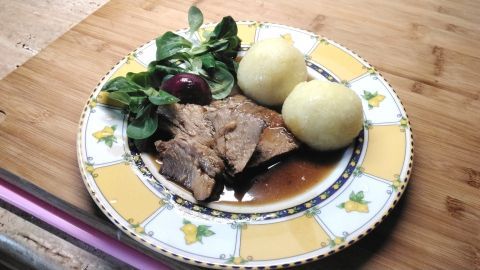 Probier den saftigen Schweinenacken-Braten mit pikanter Soße, Knödeln und frischem Salat – ein Fest für deinen Gaumen.
