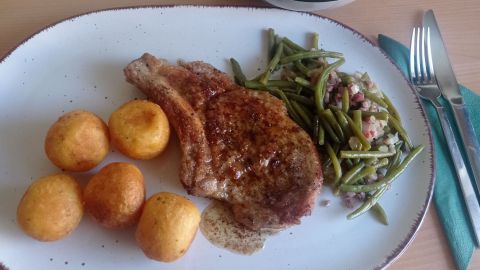 Kalbskotelett mit knusprigen Kartoffelbällchen, grünen Bohnen und frischem Salat - ein Rezept für ein köstliches Sonntagsessen.