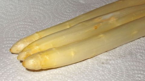 Geschälter Spargel liegt auf einem Papiertuch und zeigt seine frische, glatte Oberfläche in einer sauberen Küche.