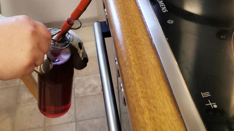 Unser selbstgemachter Traubensaft wird durch einen Entsafter in sterile Flaschen abgefüllt.