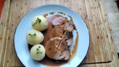 Ein saftiger Putenrollbraten aus dem Backofen, dazu eine schmackhafte Soße und Knödel.