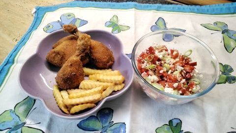 Backhendl auf Wiener Art – innen saftig, außen knusprig und kross – mit Salat und Pommes serviert.