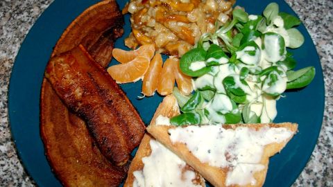 Schweinebauchscheiben mit Fenchelgemüse, angerichtet mit Trüffelbutter-Toast und ein paar Mandarinenstückchen.