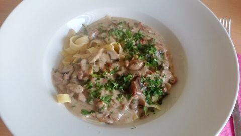 Die Tagliatelle werden abgegossen, mit der Pilzrahm-So&szlig;e gemischt und in Pastatellern appetitlich angerichtet.