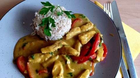 Puten-Curry aus dem Artikel: zarte Putenstreifen in cremiger Currysauce mit Paprika, dazu Reis und gr&uuml;ner Salat.
