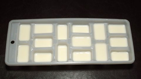 Ein Silikonbehälter mit kleinen Fächern enthält frische Sahne, bereit zum Portionieren in der Küche.