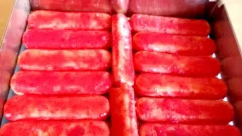 Saftig rote L&ouml;ffelbiskuits bilden die Basis des Erdbeer-Tiramisu aus dem Rezept &ndash; hier siehst Du die erste Schicht im Rahmen