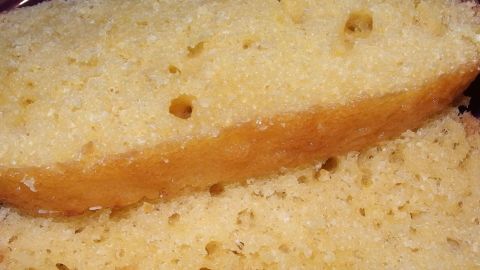 Der Joghurtkuchen liegt auf einem Teller, zwei saftige Scheiben sind geschnitten und präsentieren sich appetitlich.