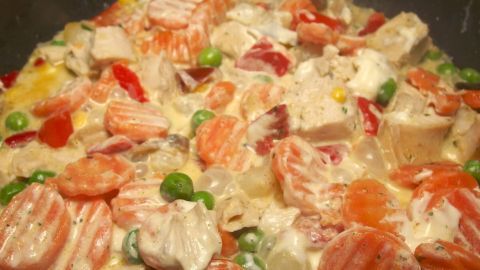 Bunte Mischung aus TK Pfannengemüse wird in einer Pfanne erhitzt, um eine leckere Sauce zu integrieren.