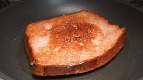 Leberkäse und Pellkartoffelsalat - ein schnelles Gericht für alle Kochanfänger. Ein leicht gebräuntes Stück Toast brät in einer Pfanne, ideal für ein schnelles Gericht für Kochanfänger.