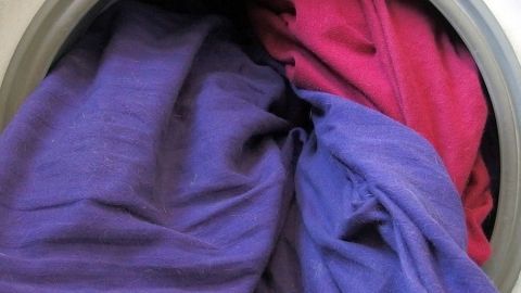 Bettwäsche in leuchtenden Farben liegt in einer Waschmaschine, während sie gewaschen wird, um frisch und sauber zu sein.