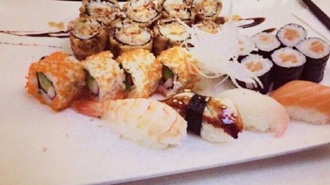 Ein Teller mit selbstgemachtem Sushi zeigt verschiedene Sushi-Rollen und Nigiri, schön angerichtet für ein festliches Essen.