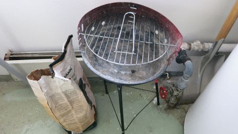 Ein Grillrost steht auf einem Ständer, umgeben von einem Sack mit Waschpulver, bereit zur einfachen Reinigung.