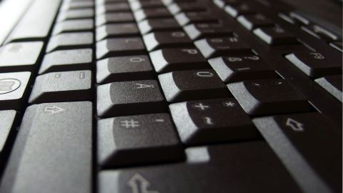 Eine Computertastatur liegt schräg auf einem Tisch, bereit zur Reinigung, ihre Tasten sind deutlich sichtbar.