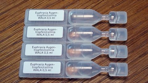 Augentropfen helfen auch gegen Pickelchen. Einfach auftragen und nach ein paar Stunden ist der Pickel weg bzw. wesentlich kleiner. Augentropfen stehen in transparenten Ampullen, bereit zur Anwendung gegen Pickel auf einem Holztisch.