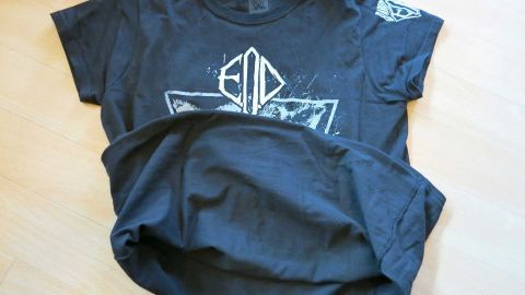 Ein schwarzes T-Shirt liegt flach auf einem hellen Untergrund, bereit zum Anziehen, um weiße Deo-Flecken zu vermeiden.