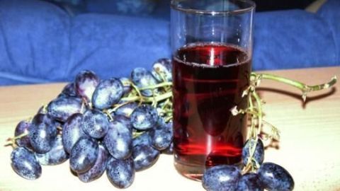 Ein Glas Traubensaft steht neben frischen Trauben und symbolisiert die gesundheitsfördernde Wirkung von Polyphenolen.