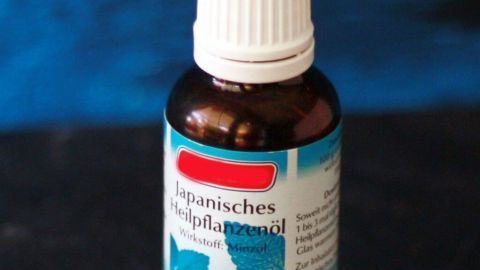 Nutze japanisches Heilpflanzenöl, um Mücken effektiv fernzuhalten. Ein paar Tropfen in eine Schale mit Wasser und die Insekten bleiben weg. Ideal für die Sommermonate und einfach anzuwenden. Mückenfrei genießen! Eine Flasche japanisches Heilpflanzenöl steht auf dunklem Untergrund. Das Etikett zeigt Minzblätter und Text: „Japanisches Heilpflanzenöl, Wirkstoff: Minzöl“.