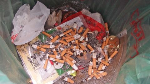 Zigarettenasche kann eine praktische Lösung sein, um Fliegen im Mülleimer fernzuhalten. Durch die Asche erhält der Abfallbehälter eine natürliche Barriere, die unliebsame Insekten abwehrt. Schütze Deinen Müll vor Fliegen! Ein Müllcontainer ist mit Zigarettenasche und -stummeln gefüllt, um Fliegen im Abfall zu bekämpfen.