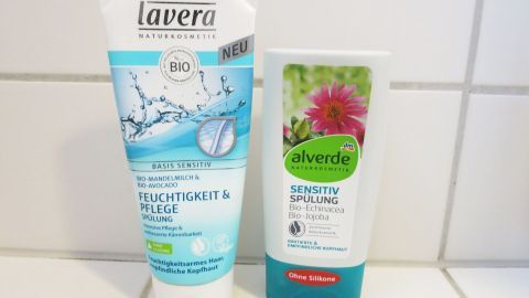 Zwei Haarspülungen stehen auf einer weißen Fliesenoberfläche, bereit zur Anwendung, um die Wirksamkeit der Haarspülung zu erhöhen.