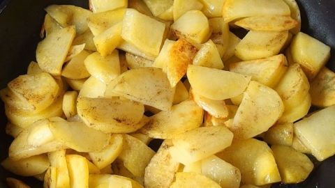 Geröstete Bratkartoffeln in einer Pfanne bräunen sanft, um beim Braten nicht zu zerfallen, umgeben von einem heißen, dampfenden Umfeld.