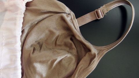 Ein Bügel-BH liegt auf einem dunklen Tisch und zeigt die Form und Struktur des Stoffes, bereit für die Waschmaschine.