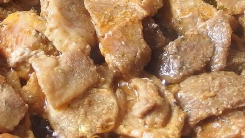 Zartes Gyros brutzelt in einer Pfanne, während es goldbraun wird und aromatische Düfte verströmt.