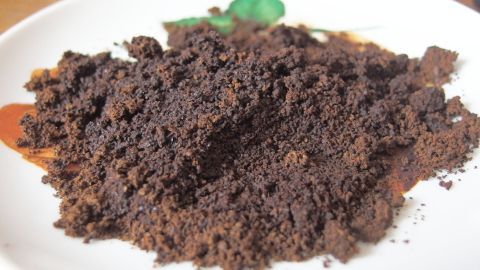 Kaffeepulver liegt auf einem Teller, um Kühlschrankgerüche zu neutralisieren und das Raumklima zu verbessern.