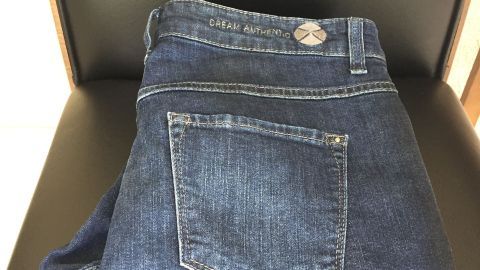 Auf einem Stuhl liegen ordentlich gefaltete Jeanshosen, bereit für den nächsten Gebrauch ohne Bügeln.