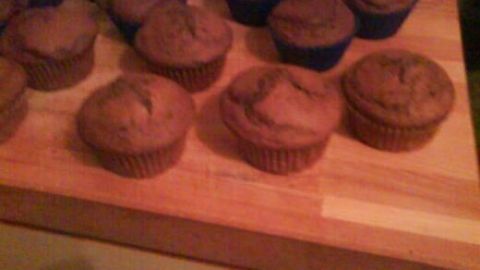 Nutella-Muffins auf einem Holzbrett, arrangiert in Papier- und Silikonförmchen. Sie sind frisch gebacken.