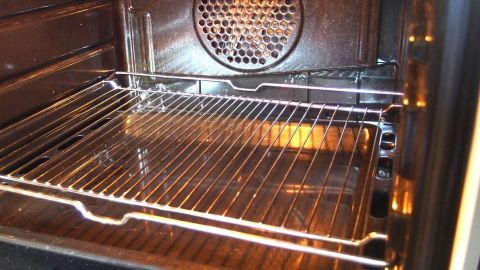 Ein Backofen mit einem herausnehmbaren Rost ist geöffnet, bereit zur Reinigung mit Rasierschaum, um Schmutz zu entfernen.