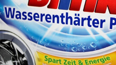 Eine Verpackung eines Wasserenthärters zeigt aktiv sprudelndes Wasser, umgeben von klaren, blauen Farben und Hinweisen auf Zeit- und Energieeinsparungen.