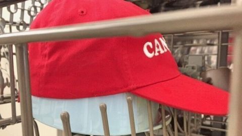 Eine rote Base Cap wird in einem Geschirrspüler auf einem oberen Regal gewaschen, um sie zu reinigen.