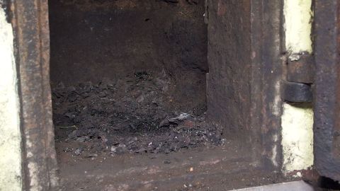 Ein offenes Schornsteinfach zeigt Rußablagerungen, die genutzt werden, um Schnecken abzuschrecken und abzuwehren.