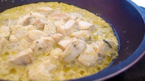 Mithilfe von Speisestärke lassen sich Fleischstücke zarter braten. In einer Pfanne braten Stücke von Fleisch in einer goldenen, würzigen Sauce, um asiatische Aromen zu erzeugen.