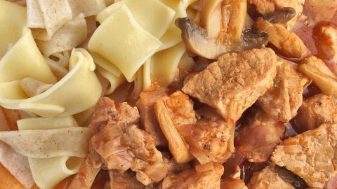 Zartes Fleisch und Bandnudeln liegen in einer Schüssel, umgeben von einer würzigen Malzbier-Sauce.