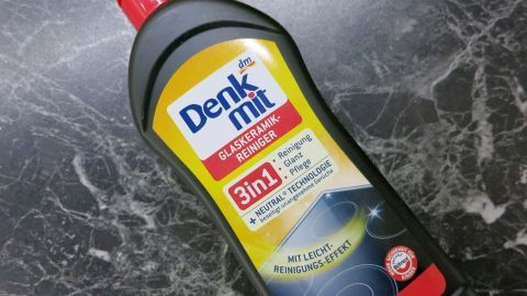Eine Flasche mit Denkmit Reinigungsmittel steht auf einer glatten, dunklen Fläche und ist für die Entfernung von Kalkflecken gedacht.