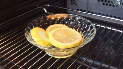 Eine Glasschüssel mit Zitronenscheiben steht in der Mikrowelle, um sie ohne Chemie zu reinigen und Gerüche zu entfernen.
